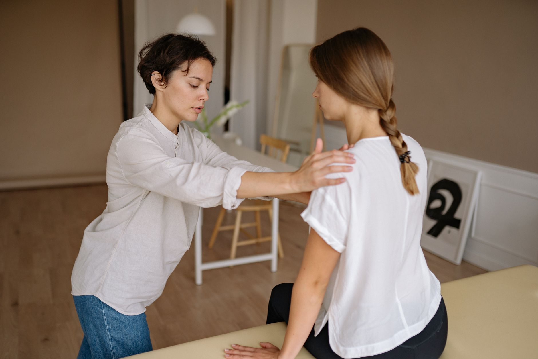 A massage therapist works with a client in a calming indoor setting, why shoulder pain comes back after it heals